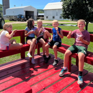 Prairie Raised Beef Summer Camp Farm Camp Sauk City, Wisconsin kids on wagon ride eating a snack